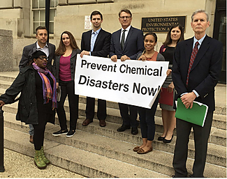 People on steps with Prevent Chemical Disasters banner